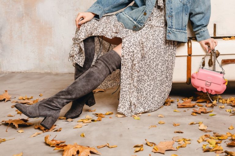 attractive stylish blonde woman jeans oversize jacket walking against wall street 1
