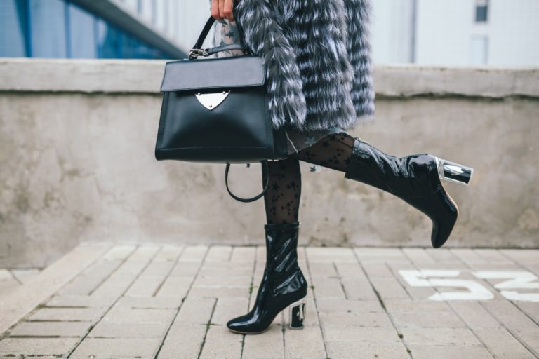 close up accessories details stylish woman walking city warm fur coat winter season cold weather holding leather handbag legs boots footwear street fashion trend 1