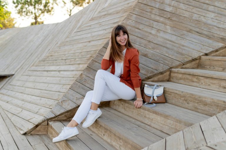 happy stylish female student posing modern park wesring white jeans jacket t shirt 1